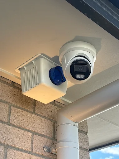 CCTV camera and junction box installed under a home's eave