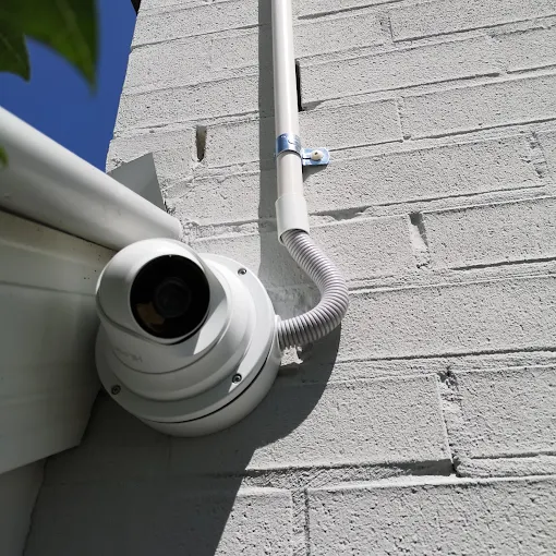 Dome security camera neatly mounted on a white brick wall